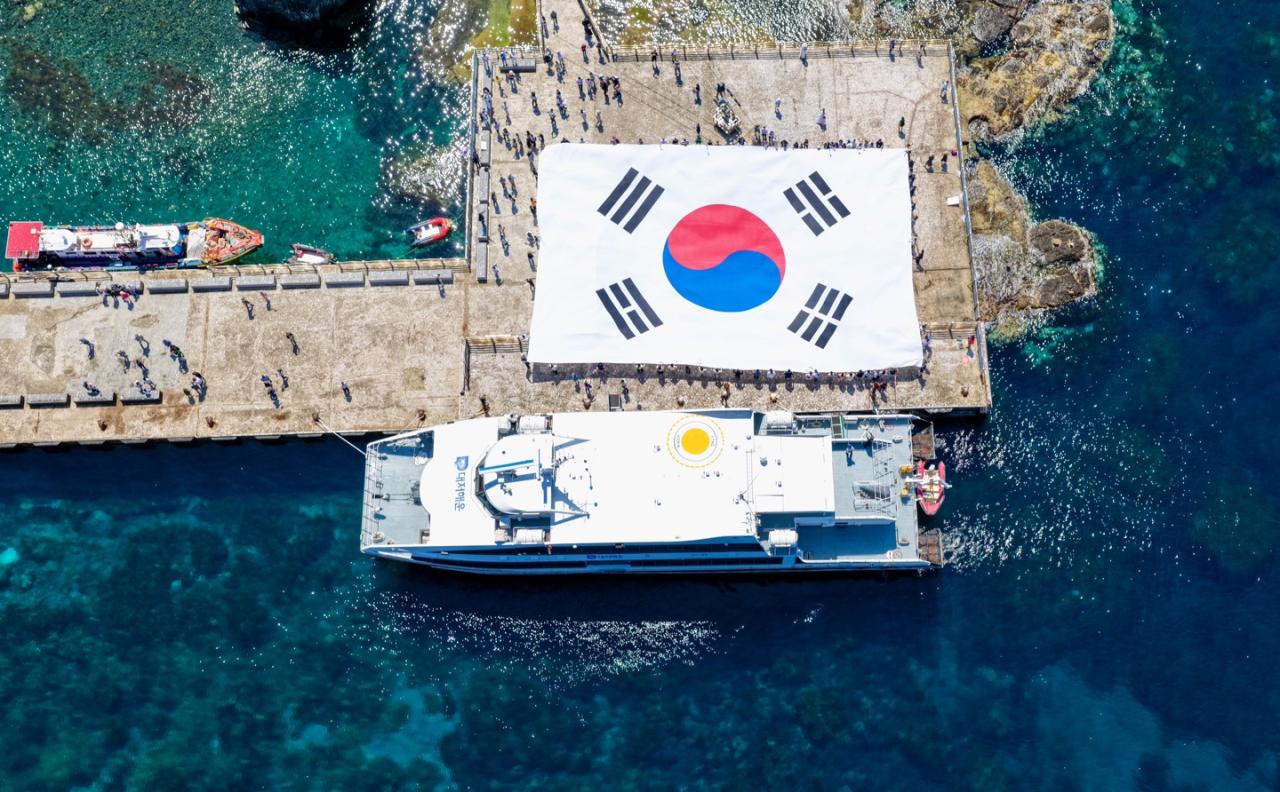 -지난 28일 시민 70명이 독도 동도 선착장에서 가로 30m, 세로 20m 규모의 초대형 태극기를 펼치고 있다 (사진 = 투리스타 조성운대표 제공)