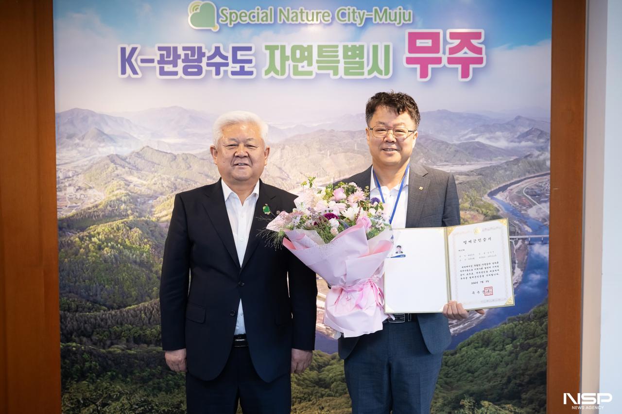 -황인홍 무주군수(사진 왼쪽)가 김성수 전북은행마케팅기획부장에게 명예군민증을 수여하고 있다. (사진 = 전북은행)