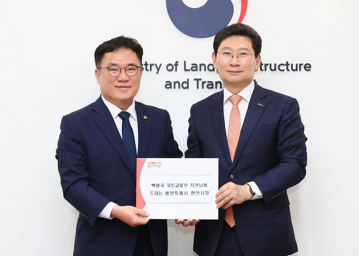 -이상일 용인특례시장(오른쪽)이 2024년 6월 5일 백원국 국토교통부 제2차관을 만나 교통망 확충 건의안을 전달하고 있는 모습. (사진 = 용인특례시)