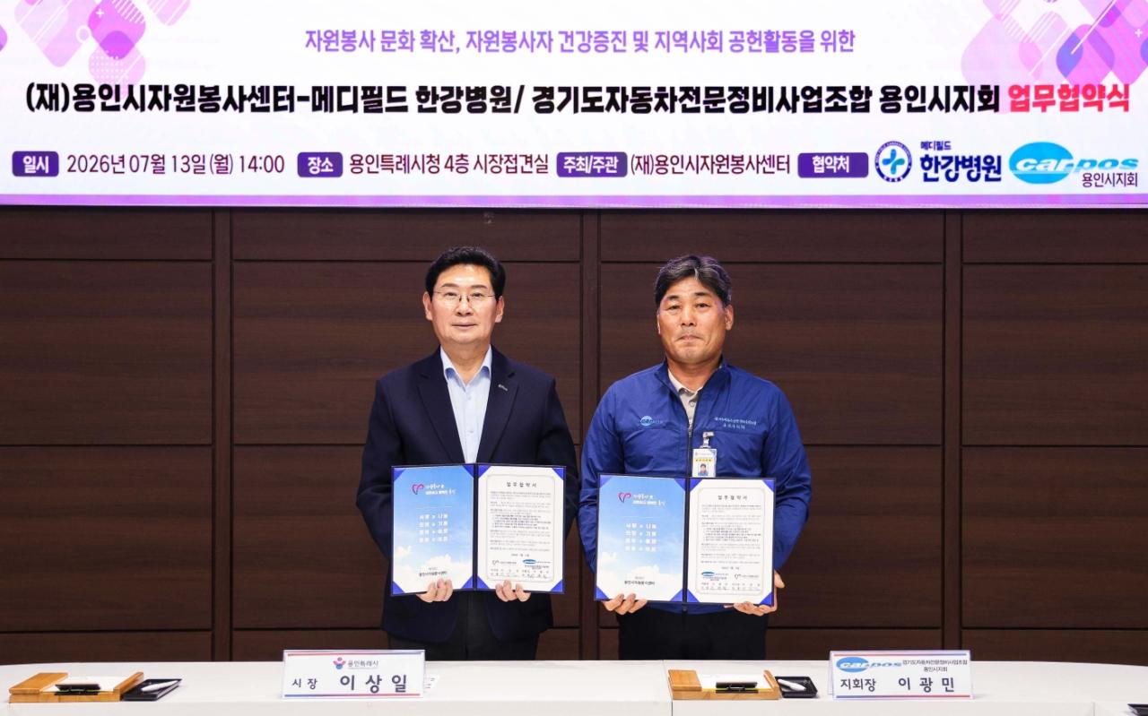 -이상일 용인특례시장(왼쪽)과 이광민 경기도자동차전문정비사업조합 용인시지회장이 자원봉사자 지원을 위한 업무협약서에 서명했다. 사진은 업무협약 체결 기념촬영 모습. (사진 = 용인특례