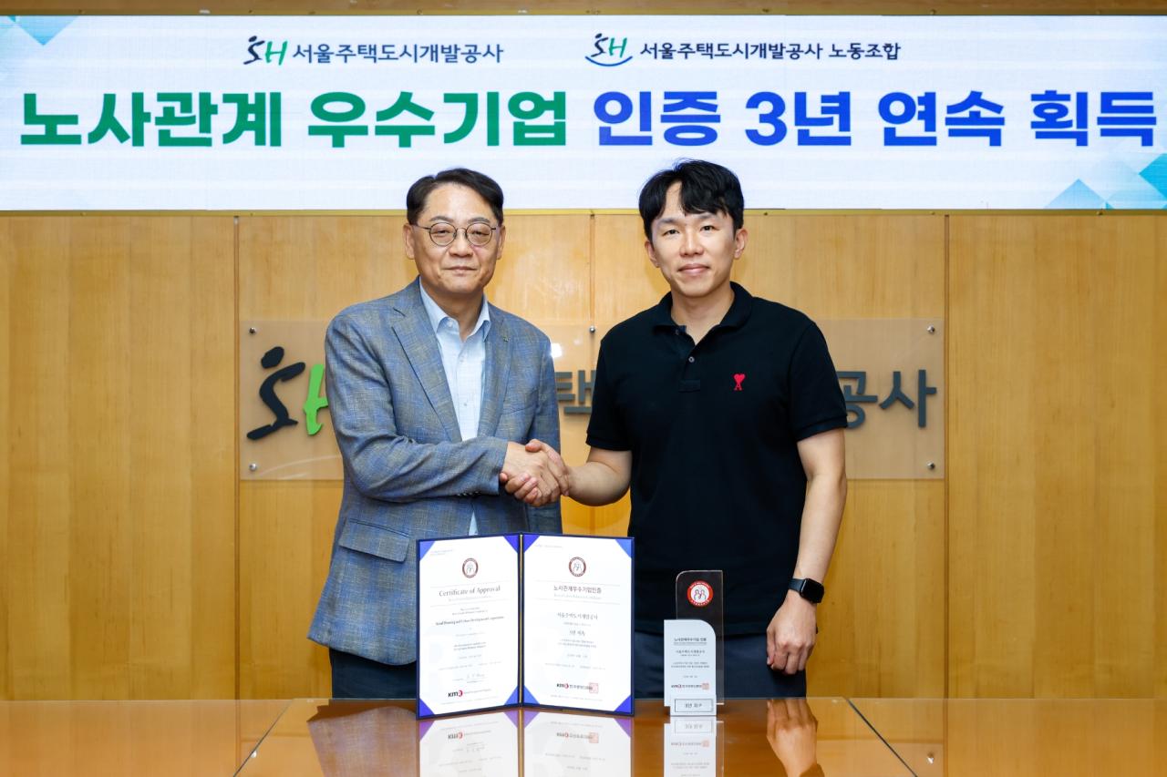 -황상하 SH 사장(왼쪽)과 남희철 서울주택도시개발공사노동조합 위원장이 노사관계우수기업 인증을 기념하며 악수하고 있다. (사진 = SH)