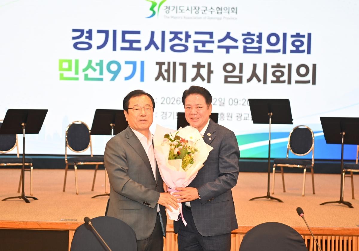 -민선9기 경기도시장군수협의회장으로 선출된 최대호 안양시장(오른쪽)이 임시회장으로서 회의를 진행한 이현재 하남시장(왼쪽)으로부터 꽃다발을 받고 있다. (사진 = 안양시)