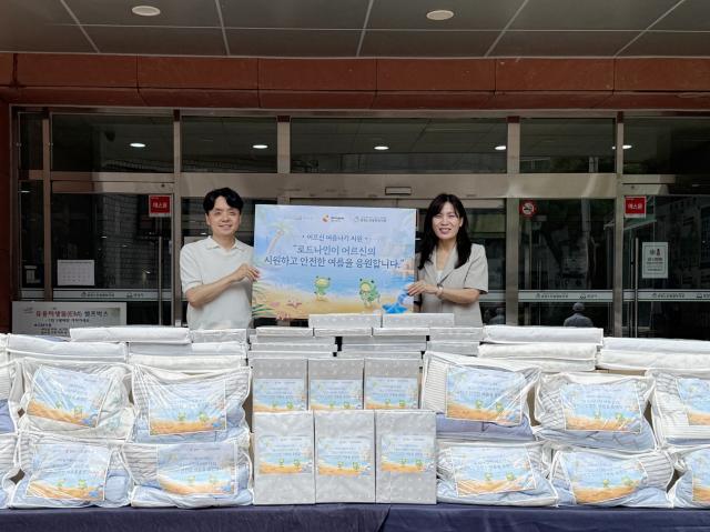 -엔엑스쓰리게임즈 용명운 콘텐츠 디렉터(좌)와 중원노인종합복지관 신명희 관장이 기념촬영을 하고 있다. (사진 = 스마일게이트)