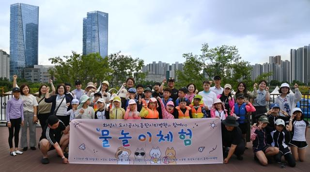 -30일 화성도시공사와 동탄시티병원, 청아재단 화성시 지역아동센터 관계자 및 참여 아동들이 물놀이 체험행사 후 기념촬영을 하는 모습. (사진 = 화성도시공사)