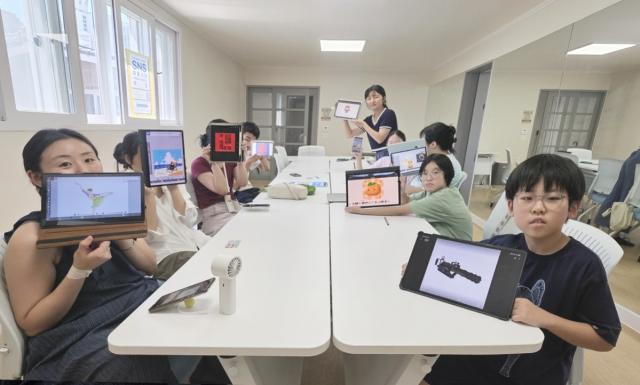 용인특례시 신갈오거리 도시재생 거점공간인 관곡마을 실버케어센터에서 운영한 ‘디지털 드로잉 굿즈 만들기’ 프로그램 참가자들이 개인 기기를 활용해 직접 완성한 그림을 선보이고 있다.