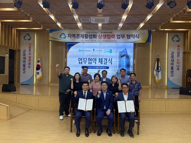 11일 군포새마을금고 본점 대강당에서 군포시새마을금고와 당동로시장 상인회가 지역경제 활성화를 위한 업무협약을 체결한 가운데 기념촬영을 하고 있다. (사진 = 군포시)