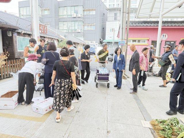 봉사단체 산애삶애 회원들과 문승옥 구례군의회의장, 김우정 부의장, 서연희 의원이 상인과 이용객들에게 얼음물과 식혜 나눠 주고 있다 (사진 = 구럐군청)