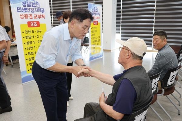 사순문 장흥군수(사진 왼쪽)가 민생안정지원금 지급 현장을 찾아 군민들의 목소리를 청취하고 있다. (사진 = 장흥군)