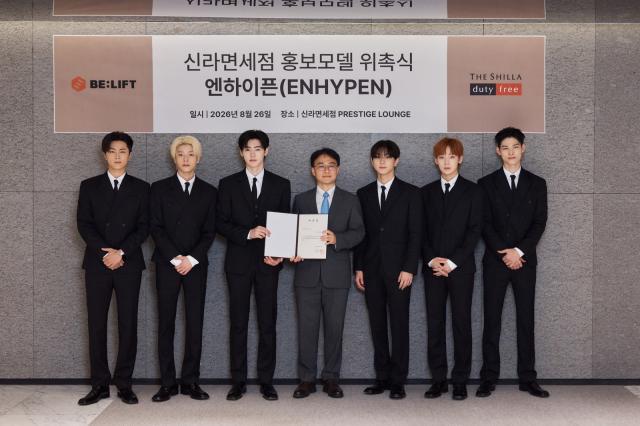 지난달 26일 신라면세점 서울점에서 진행된 ‘신라면세점 홍보모델 위촉식’에서 안재호 신라면세점 판매지원팀장(상무)과 홍보모델 엔하이픈이 기념사진을 촬영하고 있다. (사진 = 호텔신