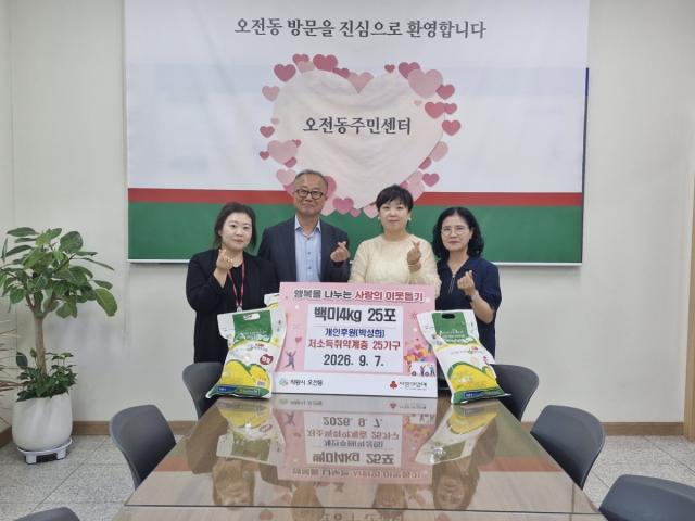 박성희 씨가 소외계층을 위한 4kg 백미 25포를 오전동주민센터에 기증한 가운데 기념촬영을 하고 있다. (사진 = 의왕시)