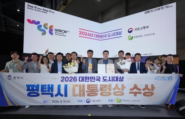국토교통부 주관 ‘2026 대한민국 도시대상’에서 대통령상을 수상한 평택시 관계자들이 9일 시상식 현장에서 ‘평택시 대통령상 수상’ 현수막을 들고 기념촬영을 하고 있다. (사진 =